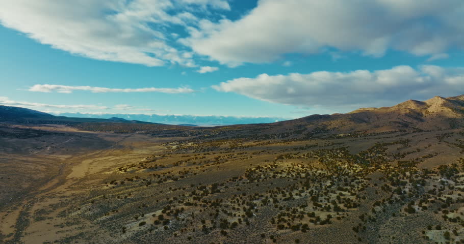 Drone shot of Nevada high desert early in the morning. Camera slowly flies past mountains
