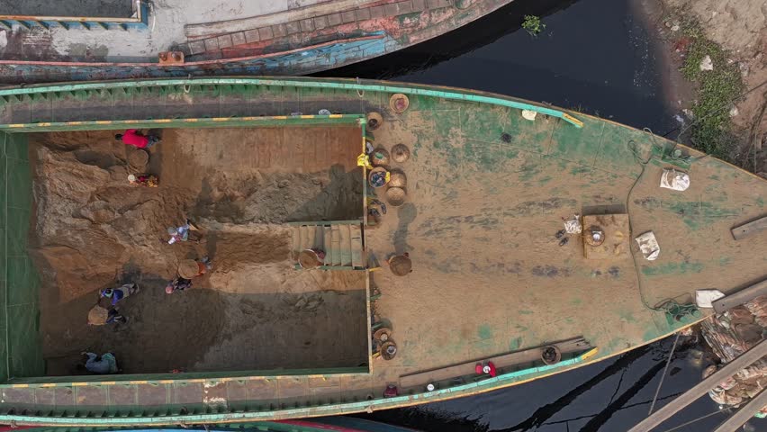 Aerial view of busy boats and people working along the river with sand banks, Dhaka, Bangladesh.