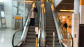 Girls are going down the escalator. Escalator in motion on airport grounds. Out of focus. - Powered by Shutterstock - Get 15% off with code: PIKWIZARD15