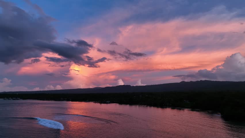 Aerial view of a moody sunrise over a tropical island with vibrant reflections on the water, Apia, Tuamasaga, Samoa.
