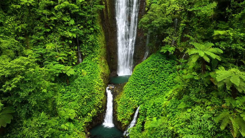 Aerial view of a breathtaking waterfall surrounded by lush tropical forest and vibrant greenery, Apia, Tuamasaga, Samoa.