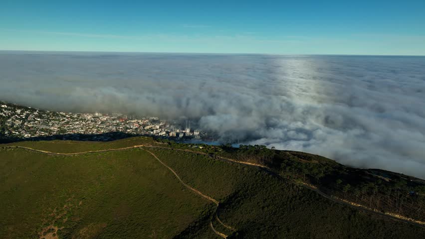 Aerial view of fog-covered Cape Town at sunrise with hills and cityscape, Western Cape, South Africa.