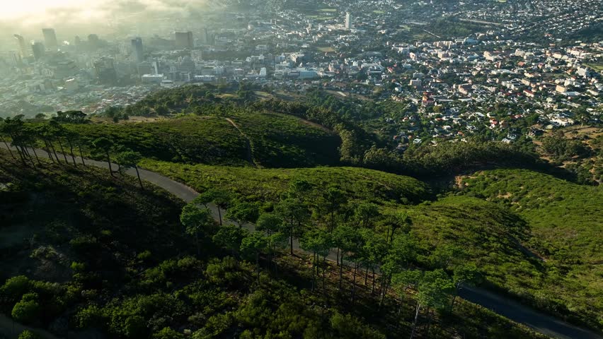 Aerial view of cape town shrouded in fog at sunrise with coastal landscape and mountains, cape town, western cape, south africa.