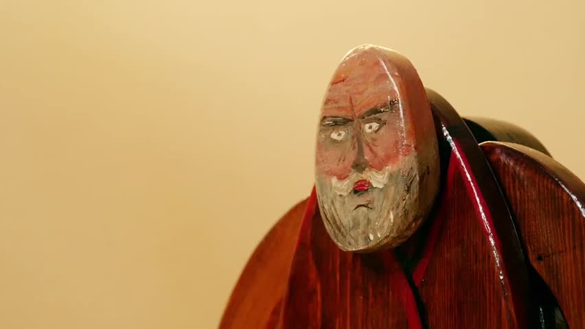 old man shakes his head negatively, wooden sculpture, slow motion