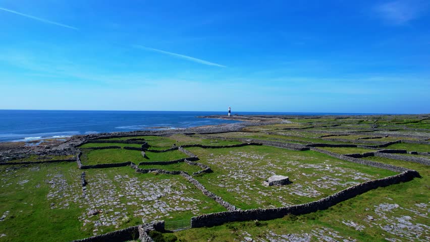 Drone flying low over rugged island to Lighthouse Inisheer Aran Islands Ireland remote epic locations