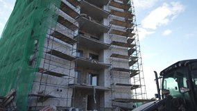 Incomplete office tower wears ragged tarps flapping noisily in strong wind. Workers in hard hats move cautiously across metal frameworks - Powered by Shutterstock - Get 15% off with code: PIKWIZARD15