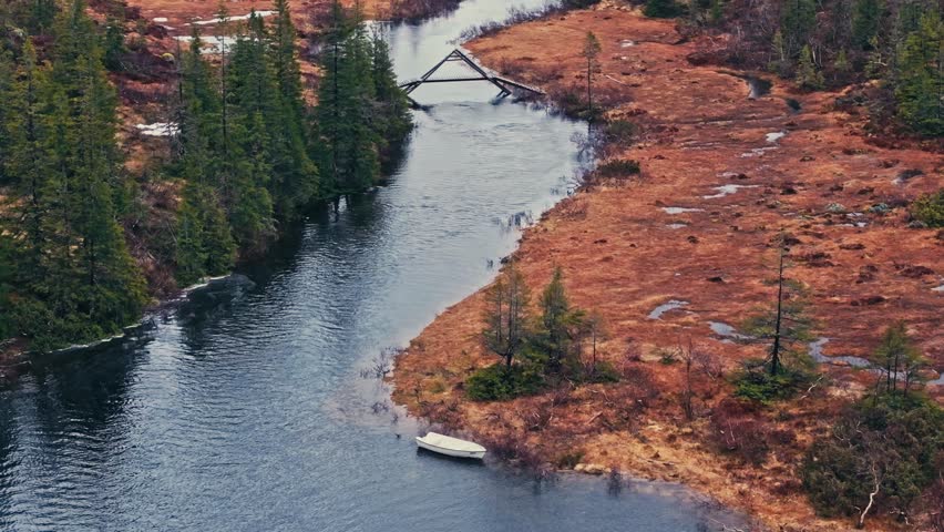 Docked Boat With A Small Wooden Bridge Over River In Norway. Aerial Shot