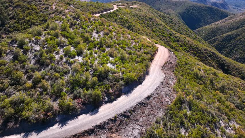 Aerial view of winding road through serene forested mountains and hills, Tonto National Forest, Gila County, Arizona, United States.