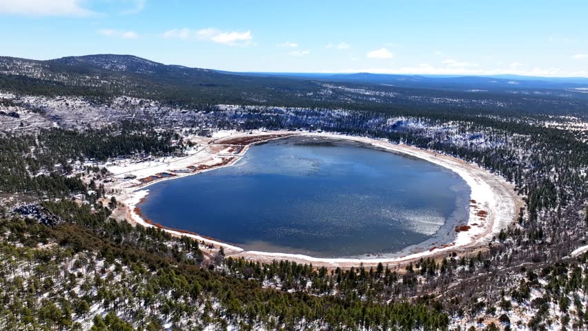 Aerial view of stoneman lake surrounded by serene winter forest and tranquil water, Northern Arizona, United States.