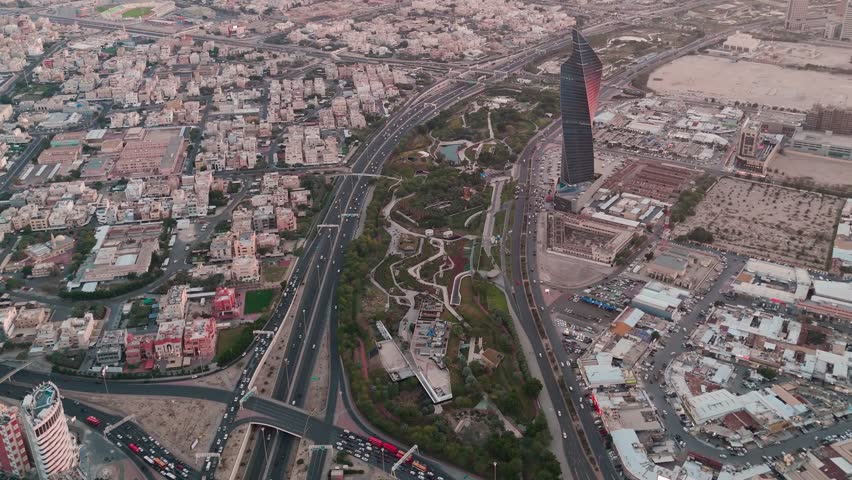 Wide aerial shot of Kuwait City’s highway network, Al Shaheed Park, and surrounding districts captured at dusk—perfect for urban, traffic, or city planning visuals.