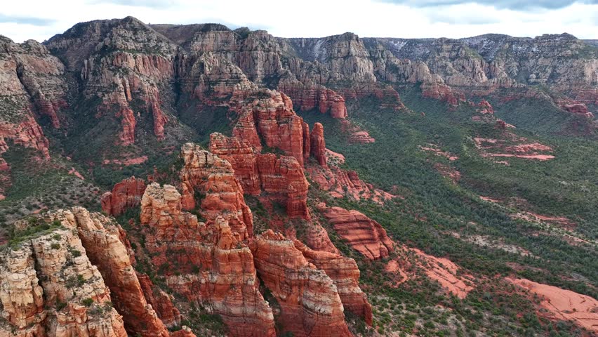 Aerial view of majestic rock formations and a tranquil valley with Oak Creek, Sedona, Arizona, United States.