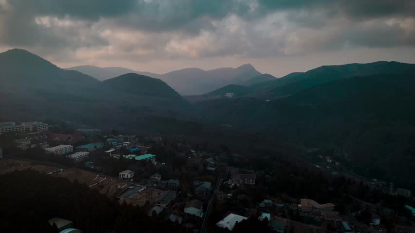 A Tranquil view of Lake Ashi, Japan, surrounded by misty mountains under a calm blue sky