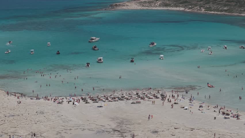 Aerial orbit view of Balos Beach and Balos Lagoon with a lot of people and boats, drone shot 4k, Crete, Greek Islands, Greece - 4K stock video 3x telephoto lense D-Log M profile