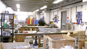 Time lapse clip of a busy team of manual workers in a factory or warehouse. 