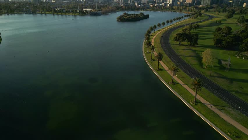 Aerial view of beautiful cityscape featuring a vibrant skyline and serene lake surrounded by greenery and modern architecture, Melbourne, Victoria, Australia.