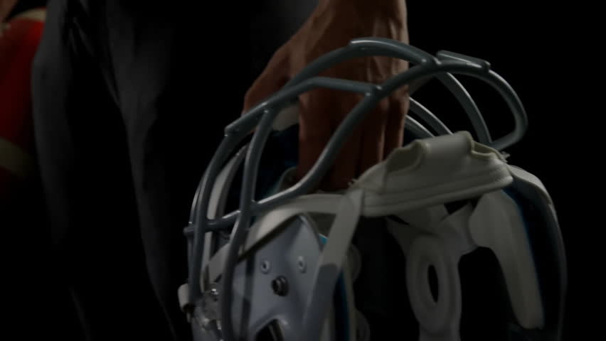 Football player holding helmet and ball when encryption code fading in showing cybersecurity fusion. Athlete, sports, technology, digital, cybersecurity, data, digital art