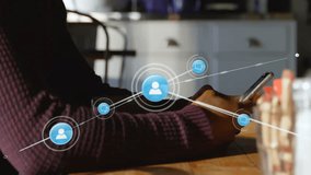 Man sitting at table holding smartphone and watching circular icon forming digital network. Technology, connectivity, communication, innovation, digital, networking, modern - Powered by Shutterstock - Get 15% off with code: PIKWIZARD15