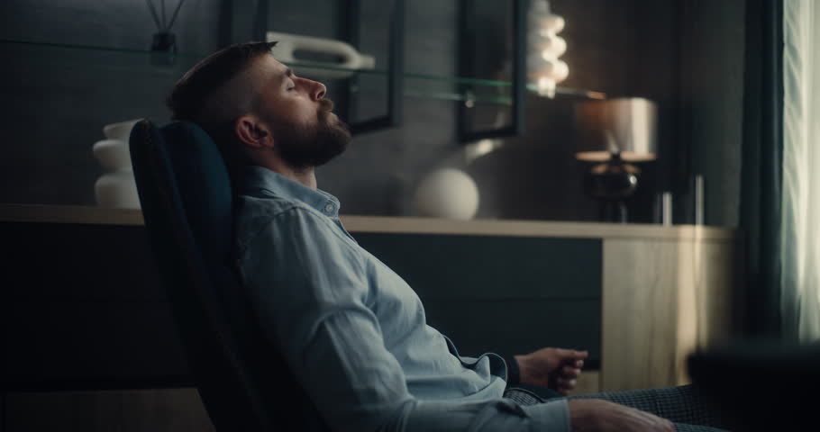 Professional Stock Exchange Broker Sitting in Chair with Eyes Closed, Relaxing After Work and Successful Trading Day. Investment Agent in Modern Home Office or Financial Agency Office. Dolly Shot.