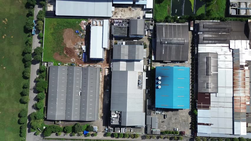 A top-down aerial view showing the roofs of multiple industrial warehouses and factory buildings in a well-organized manufacturing area in Indonesia.