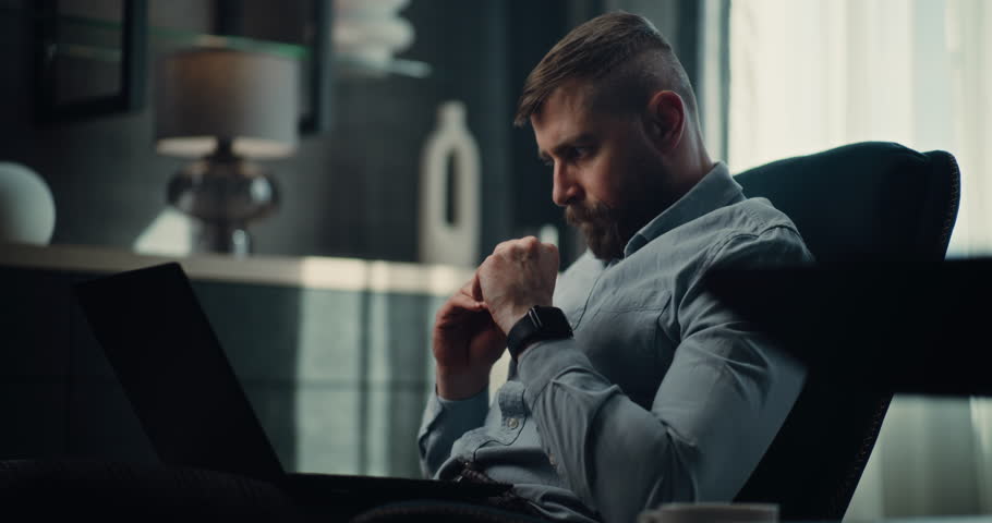 Sad Professional Stock Exchange Trader Monitoring Real-Time Stocks and Exchange Market Charts on Laptop, Suffering from Financial Crisis. Investment Agent Stressed About Sudden Stock Market Collapse.
