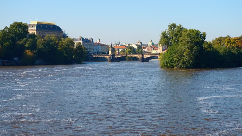 Vltava river flowing under legion bridge in prague. Legion bridge spanning vltava river connecting lesser quarter with old town, featuring national theatre landmark against scenic prague cityscape
