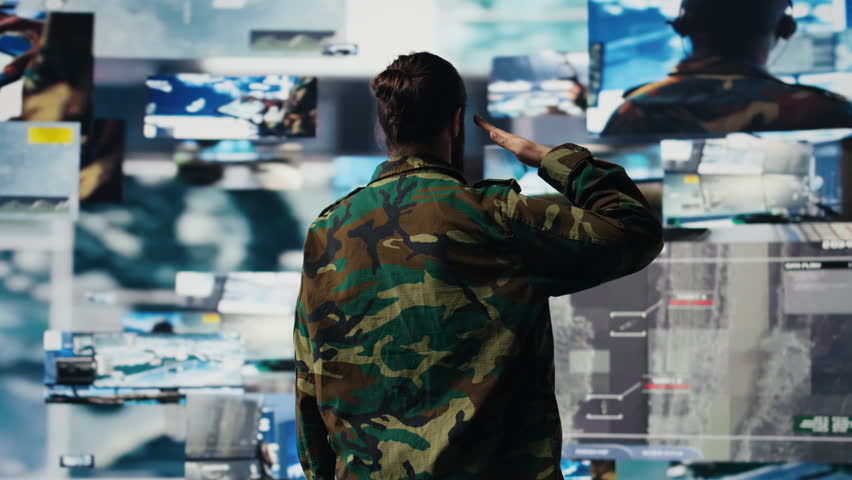 Veteran does military salute after reviewing satellite data in a control center, working on war planning tactics with battlefield details. High tech army environment for national safety. Camera B.