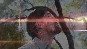 Man standing under canopy tilting head back and tech digits emerging and fading showing treetops. Nature, technology, digital, serene, futuristic, enlightenment, innovation - Powered by Shutterstock - Get 15% off with code: PIKWIZARD15