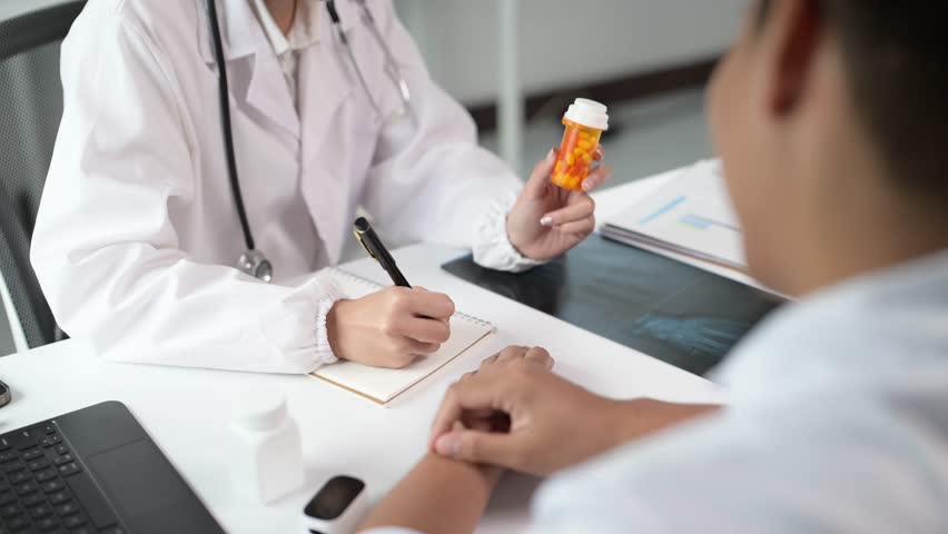 A doctor is talking to a patient about a prescription. The patient is holding a bottle of pills