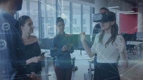 Woman donning VR headset and gesturing to colleagues for tech demo with network graphics streaming. Technology, innovation, collaboration, digital, futurism, office, teamwork - Powered by Shutterstock - Get 15% off with code: PIKWIZARD15