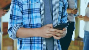 Teen female swiping smartphone in loft office, displaying animated financial data grids and charts. Technology, data visualization, finance, innovation, teamwork, modern, communication - Powered by Shutterstock - Get 15% off with code: PIKWIZARD15