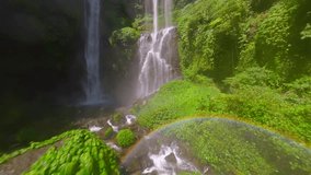 Slow motion FPV drone shot soaring above the splashing Sekumpul Waterfall in Bali, Indonesia, rising from the water surface to dive into jungle with cinematic movement and tropical scenery. - Powered by Shutterstock - Get 15% off with code: PIKWIZARD15
