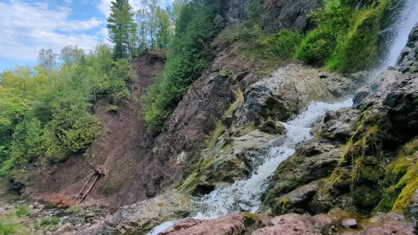 Water spills over mossy cliffs at Douglass Houghton Falls in the Keweenaw Peninsula of Michigan