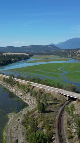 Aerial View of Majestic British Columbia Landscape with River, Road, and Mountains in Canada
