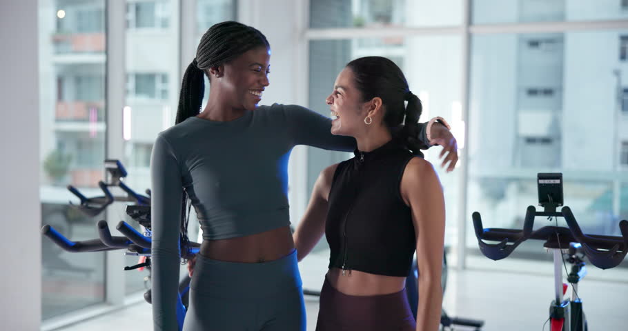 Face, indoor cycling and happy friends at gym for fitness, health and hug for support. Stationary bike, team and spin class for exercise with embrace, laugh or portrait of women with personal trainer