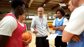 Professional basketball coach sharing strategic game plan with diverse team members, fostering communication and team unity in gymnasium setting - Powered by Shutterstock - Get 15% off with code: PIKWIZARD15