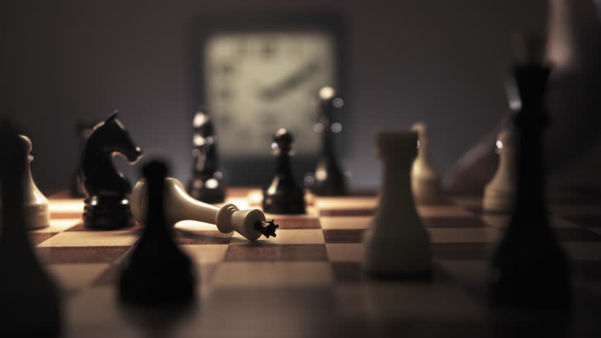 The white king lies swinging on the chessboard among the chess pieces