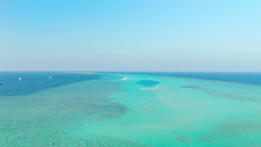An awe-inspiring aerial drone view captures the Rasdhoo Sandbanks glowing under the soft, golden light of sunset in the Maldives.
