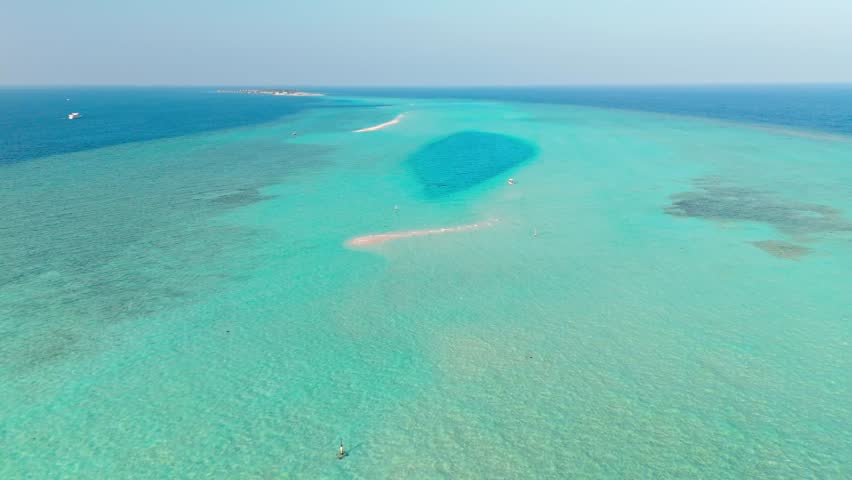 An awe-inspiring aerial drone view captures the Rasdhoo Sandbanks glowing under the soft, golden light of sunset in the Maldives.