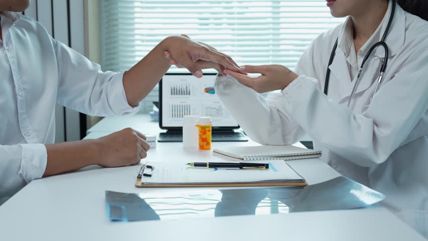 Medical professional examines a patient's hand, providing consultation and care