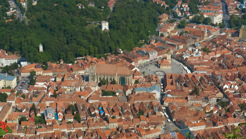 Brasov city revealing medieval architecture. Camera panning over brasov city in romania, revealing its medieval architecture with iconic red rooftops and lush green surroundings