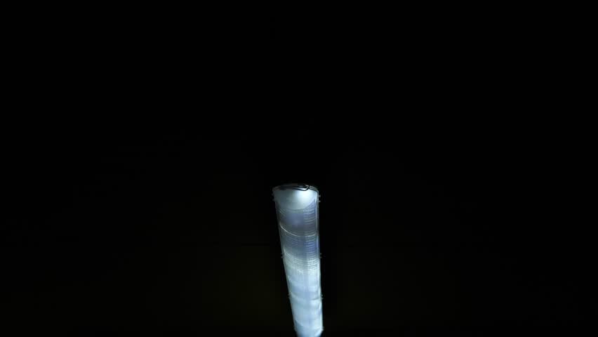 A long winding tunnel with old lamps and wires. A dark corridor with flashing and broken lamps on the ceiling, a creepy place underground, catacombs. Nuclear war, bomb shelters, underground tunnel.