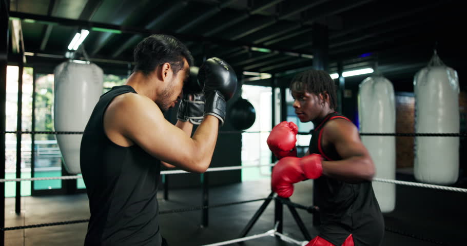 Combat, fitness and sports with people in boxing gym for self defense, sparring or training. Boxer, exercise and fight with men punching in ring for challenge, competition or performance as athlete