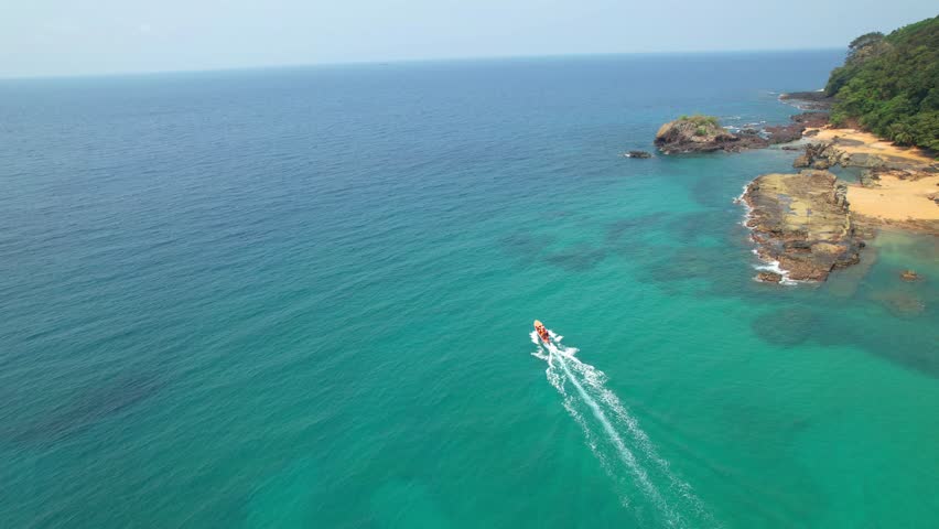 Aerial circular view from a boat with the camera rising and showing the Bom Bom islet and the walkway that connects to the beach with the same name. Ilha do Principe (Prince Island) São Tomé,Africa