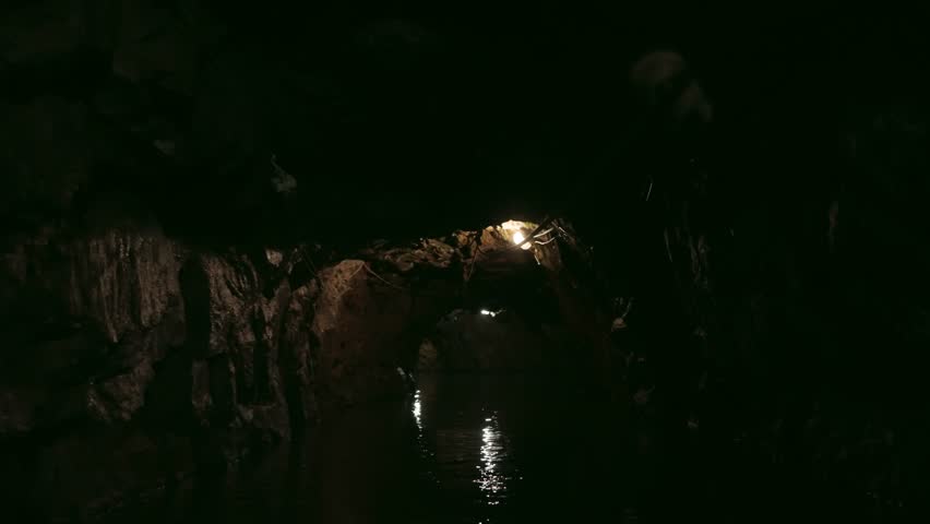 Exploring dark cave with an underground river