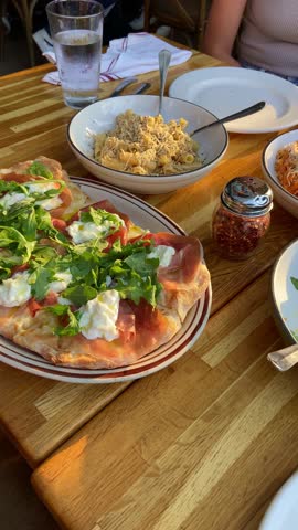 Pov of delicious tasty lunch in Italian restaurant serving salads and pasta. Table full or quality food dishes. Point of view of internet vlogger influencer filming and uploading to social media