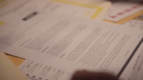 Close up on top secret document marked with rubber stamp as classified. Government agent or analyst is labeling confidential sensitive file. Red ink on important text to be kept hidden in archive - Powered by Shutterstock - Get 15% off with code: PIKWIZARD15