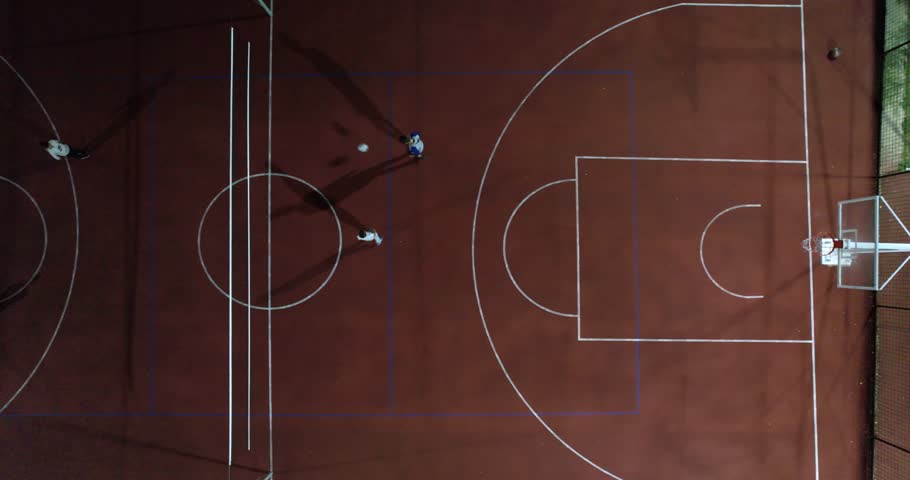 Overhead view of multi functional basketball and soccer court with players play football tennis at night