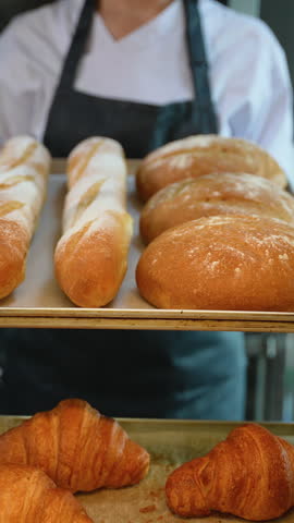 Freshly baked bread placed on cooling rack by baker