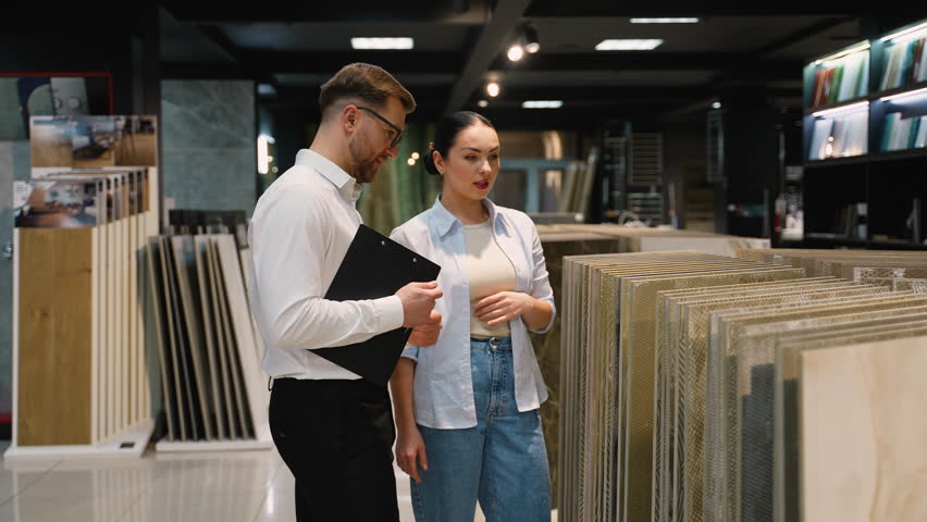 Consultant advising customer choosing tiles in hardware store