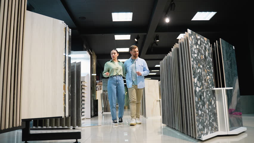 Couple choosing tiles with sales assistant in showroom
